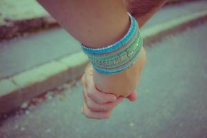 Young couple holding hands on the background of green grass photo