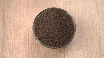 Black Tea Powder or dry dust tea powder, chai patti isolated in wooden bowl.