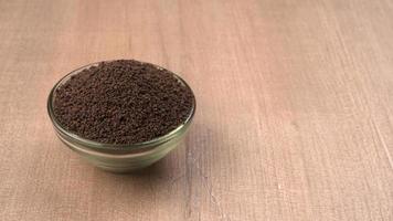 Black Tea Powder or dry dust tea powder, chai patti isolated in wooden bowl. photo