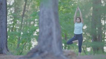 Aziatisch schattig meisje ze doet 's ochtends yoga in de tuin aan het strand. en de zon schijnt video