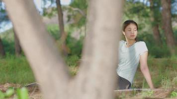 menina asiática fazendo ioga de manhã no jardim perto da praia