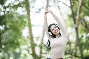 mujer asiática escuchando música favorita en auriculares. tiempo feliz y relax. foto