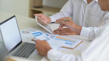 Executives with tablet are evaluating the situation of Companies to resolve the impact of the virus outbreak photo