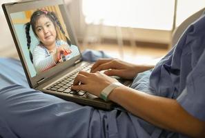 The patient is using a video call by laptop to talk to her daughter at home. photo
