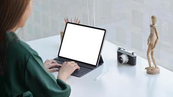 A female traveler with a camera is using a laptop to find travel information. photo