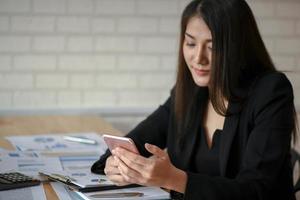 Asian female executives use mobile phone in the office.