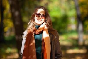 hermosa mujer joven en gafas de sol en el bosque de otoño foto