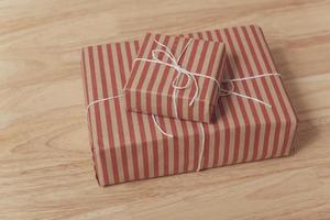 Caja de regalo roja sobre mesa de madera para Navidad y feliz año nuevo. foto