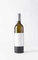 botella de vino para maqueta. etiqueta en blanco sobre un fondo gris. foto