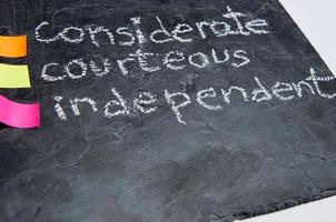 Close up of handwritten educational values. considerate, courteous and independent. Chalk on a blackboard. photo