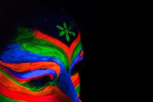 Woman with make up art of glowing UV fluorescent powder photo