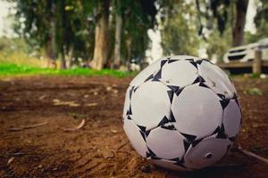 Balón de fútbol en blanco y negro sobre arena marrón
