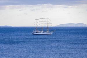 paisaje marino con un velero blanco en el horizonte