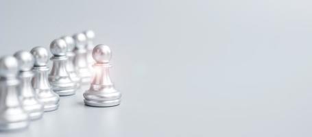 piezas de peón de ajedrez de plata o empresario líder se destacan entre la multitud de hombres. concepto de gestión de liderazgo, negocios, equipo, trabajo en equipo y recursos humanos foto