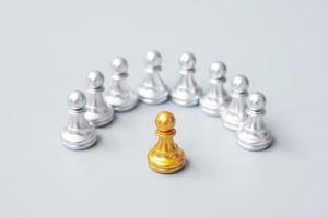 piezas de peón de ajedrez dorado o empresario líder se destacan entre la multitud de hombres plateados. concepto de gestión de liderazgo, negocios, equipo, trabajo en equipo y recursos humanos foto