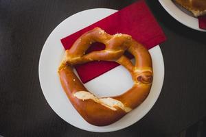 Pretzel bread on white plate on wooden table photo