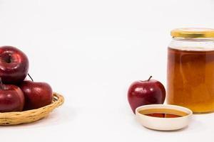 Montón de manzanas y manzana roja y tarro de miel cuenco de miel aislado sobre un fondo blanco.