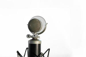 Micrófono de condensador vocal con pantalla antiviento aislado sobre fondo blanco.
