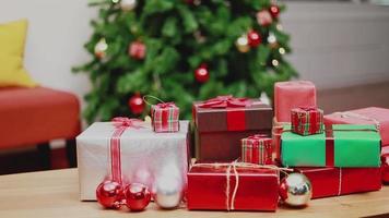 kerstcadeaudoos op tafel en verlichting ornamenten Kerstmis viert het nieuwe jaar in de woonkamer thuis. video