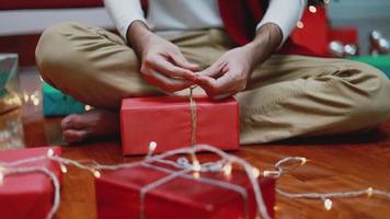 Asian man making a gift box in the living room at home. video