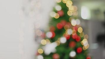 wazig achtergrondverlichting ornamenten kerstboom viert het nieuwe jaar in de woonkamer thuis. video