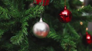 Weihnachtskugeln und Lichterschmuck Weihnachtsbaum feiert das neue Jahr im Wohnzimmer.