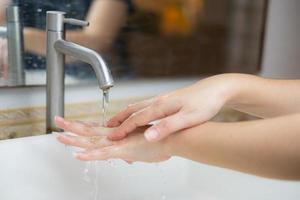 la hermosa mano femenina que aplica jabón en el fregadero o anti-bacterias para evitar la propagación de gérmenes en el fondo blanco