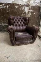 Old abandoned leather armchair photo