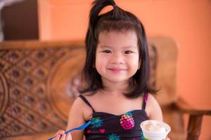 Portrait of happy kid girl sweet smile around the house. One cute Asian toddler age 3-4 years old. photo