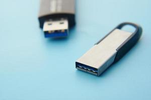 USB flash drive on blue background close up photo
