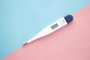 digital thermometer on pink background with copy space photo