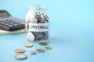 saving coins jar and calculator on table photo