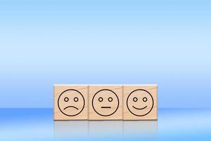 Wooden cube blocks with an emotion face symbol. Business uses a happy face on wood to represent service rating, ranking, customer review, satisfaction, and feedback. photo