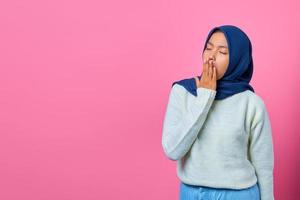 Portrait of beautiful young Asian woman feeling sleepy and covering mouth with hand photo