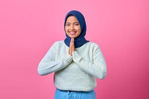 retrato, de, sonriente, joven, mujer asiática, actuación, rezando, gesto, en, fondo rosa