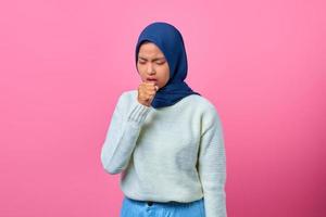 Portrait of beautiful Asian woman feeling unwell and coughing on pink background