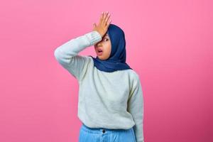 Portrait of shocked young Asian woman hand on head with disappointed expression photo