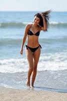 Young arabic woman with beautiful body in swimwear on a tropical beach.