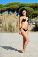 Young arabic woman with beautiful body in swimwear on a tropical beach. photo