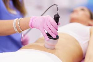 Woman receiving anti-cellulite treatment with radiofrequency machine in an aesthetic clinic.