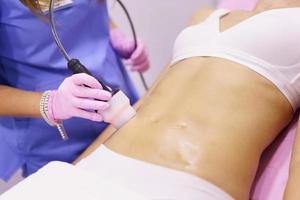 Woman receiving anti-cellulite treatment with radiofrequency machine in a beauty center. photo