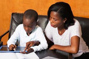 schoolboy studying with his mother. photo