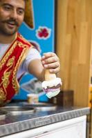 ISTANBUL, TURKEY, JUNE 15, 2019 - Unidentified seller of Turkish ice cream at Istanbul, Turkey. Traditional Turkish ice cream was made with salep, produced by orchid flowers. photo