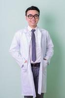 Asian doctor standing on green background photo