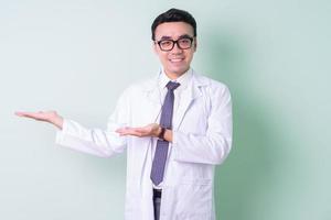 Asian doctor standing on green background photo