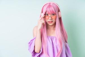 Joven mujer asiática con cabello rosado posando sobre fondo verde foto