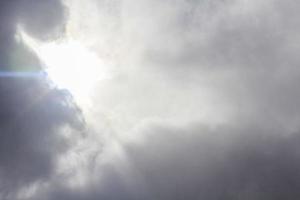 Sun comes out from behind dark storm clouds photo