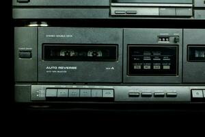 Close up front a deck recorder of the vintage stereo cassette tape player with the push operation buttons are retro technology photo