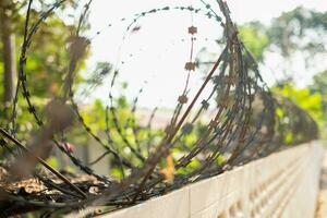 Close-up fence with barbed wire against a blurred background photo