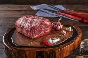Raw entrecote beef on a wood cutting board with spices. photo